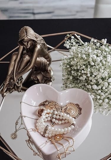 gold and white beaded necklace on white ceramic plate
