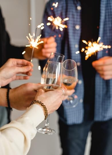 People with champagne glasses and sparklers offering a toast