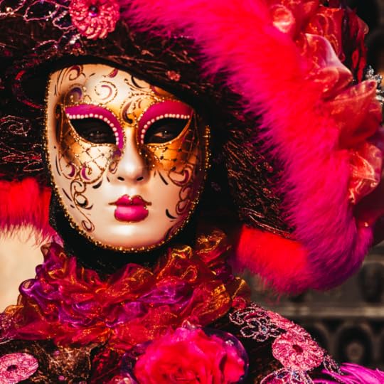 Person in red mardi gras costume with a pink feather mask