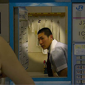 Train station employee behind ticket machines