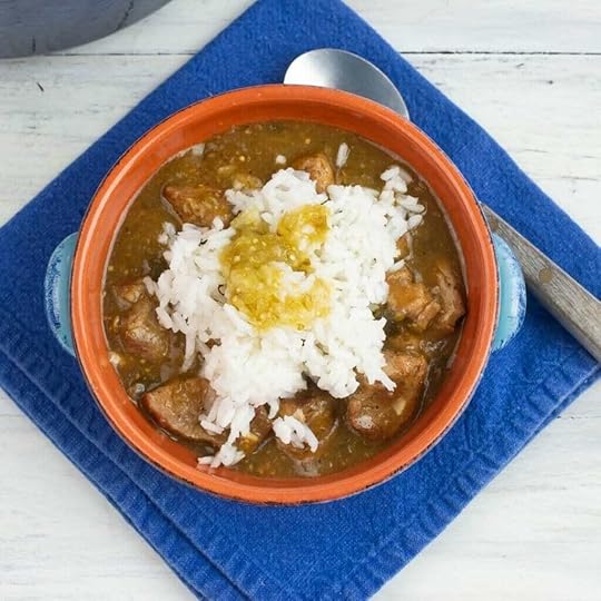 A terra cotta bowl filled with tender Green Chile Pork served with white rice and topped with Salsa Verde.