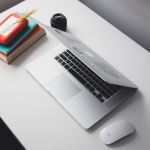 MacBook Air and Apple Magic Mouse on top of white table