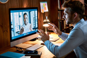 One person in the office talking over the computer to a remote teammate