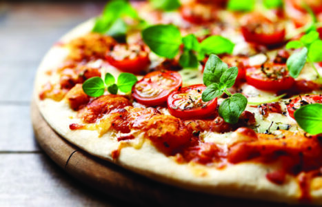 pizza with tomatoes and fresh oregano