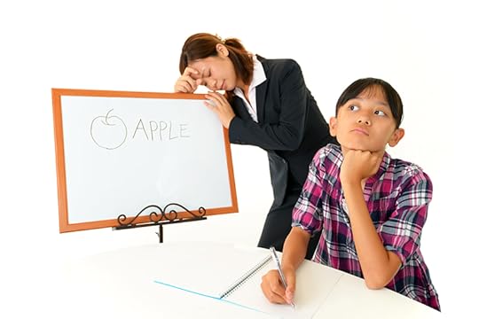 A student stares off into space, while a teacher leans on a whiteboard behind the student, showing feelings of frustration. Getting kids to pay attention is a challenging teaching situation.