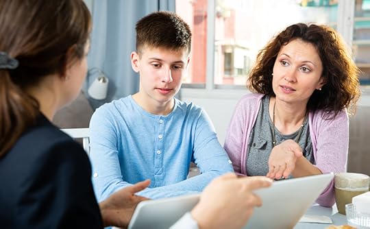 A male student and his mother meet with a teacher. Helping parents understand dyslexia is another challenging teaching situation.