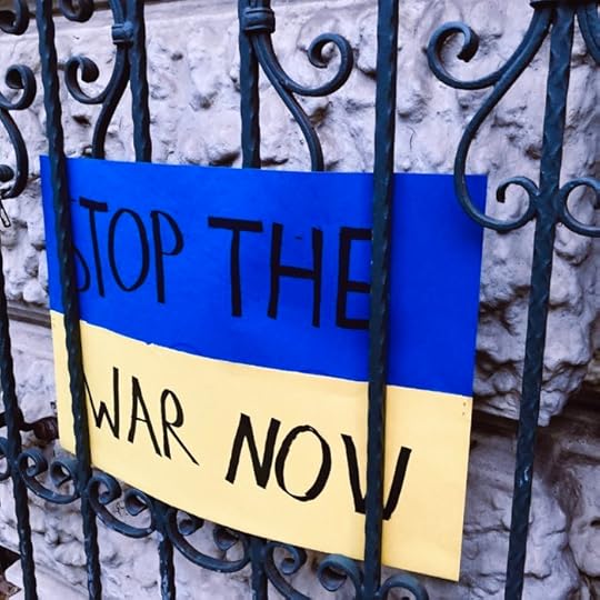 Ein Demo-Pappschild: Stop the war now, blaugelber Hintergrund