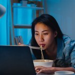 working girl eat in front laptop