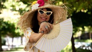 An image of a middle aged woman who is wearing a hat and sun glasses enjoying spring/summer.