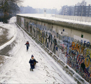 Berlin Wall, two boys walk on footpath