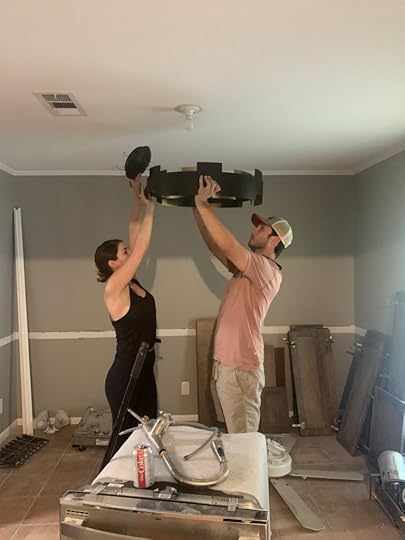Man and woman installing light fixture