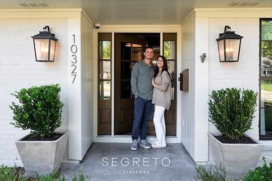 Happy couple standing in front of their home.