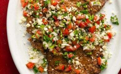 Mexican pacholas on a platter with pico de gallo salsa.