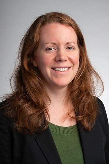Color portrait of Liz Novaro, wearing a black blazer over a green blouse.