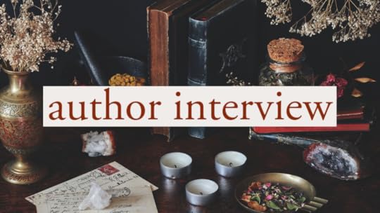 text says author interview; picture shows candles, flowers, a jar with leaves, a dish with plants, and letters and books. 