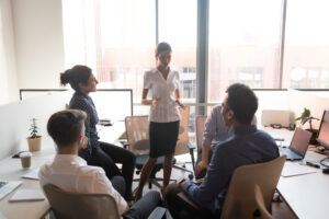 Team meeting in person with a woman presenting about the future