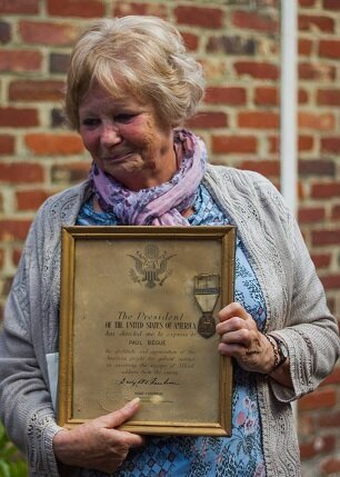 Paulette showing the French Commemorative War Medal and the US Prsedent’s certificate of gratitude awarded to her father for his Aid to American Airmen. Her pride shows in her face.
