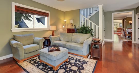 Couch in front of stairs with area rug and ottoman in living room