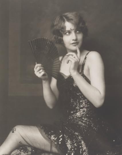 Actress Barbara Stanwyck, seated, wearing a flapper dress