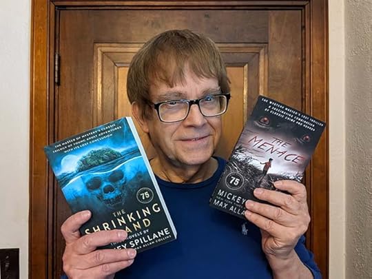 M.A.C. holding copies of The Menace and The Shrinking Island
