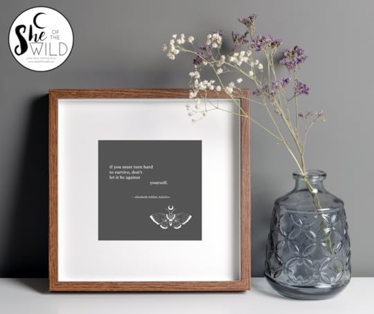framed poetry art print with a sprig of purple and white flowers in a vase, against a gray wall