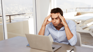Person staring into laptop looking confused