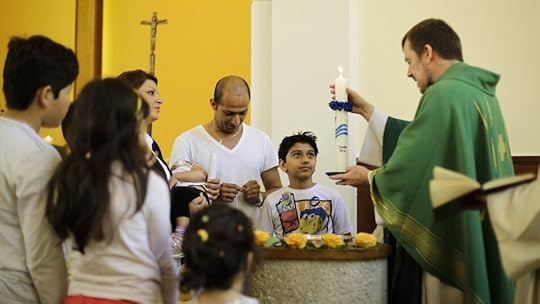 Pastor Gottfried Martens lights a candle during a service to baptize people from Iran, in the Trinity Church in Berlin. Third right is Iranian asylum-seeker Mohammed Ali Zanoobi. He is one of hundreds of mostly Iranian and Afghan asylum seekers who …
