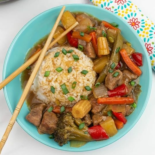Sweet and Sour Pork with a mound of white rice served in a shallow teal colored bowl.