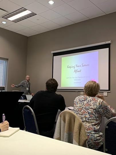 Author Ryan R. Campbell gestures to a room of attendees while starting his presentation on scene structure.