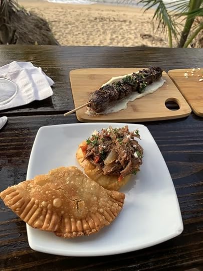 Plates of food feature empanadillas and pinchos de churrasco.