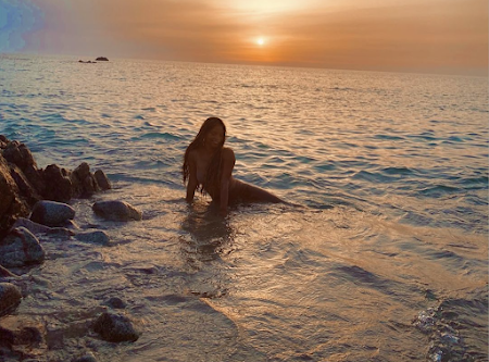 Photo Halle Bailey as Ariel in the ocean at sunset