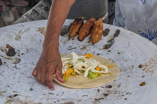Oaxaca, Mexico- July 18, 2018: a Mexican woman preparing a squash blossom quesadilla on a large comal