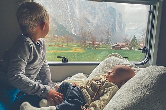 Baby in travel chair with older child looking out the window