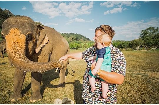 Man with baby pats elephant in Thaialand