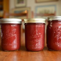 Three pint jars filled with strawberry hibiscus butter
