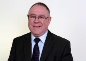 Ron Rosenhead wearing a suit and tie