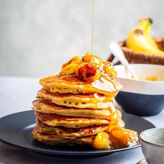 Maple syrup being poured on to a stack of buttermilk Pancakes with Caramelized Bananas