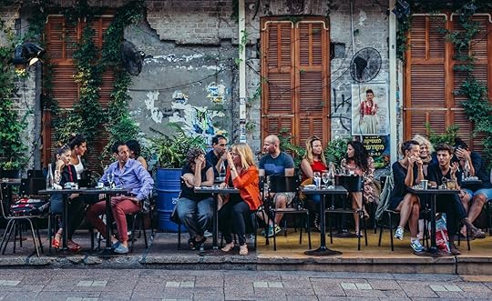 People sits at tables outside the restaurant at Rothschild Boulevard in gay Tel Aviv