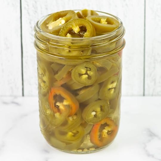 An over flowing jar of sliced pickled jalapenos.