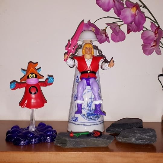 The chained Prince Adam raises the sword to transform into He-Man.