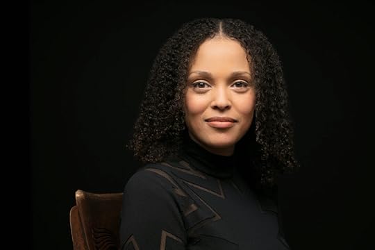 Head and shoulders portrait of Jesmyn Ward against a dark background, highlighting her face