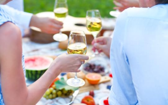 People drinking wine at an outside picnic