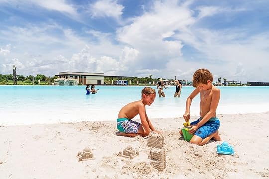 Kids playing in beach sand near blue water