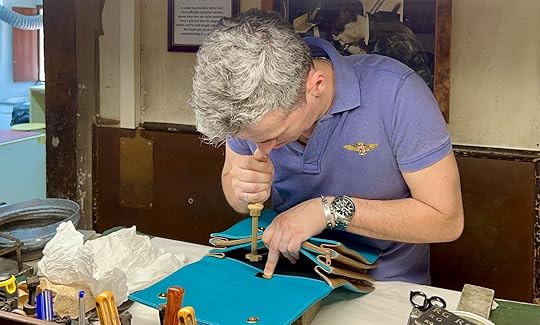 francesco galleni adds gold leaf seal to bag at scuola del cuoio in florence