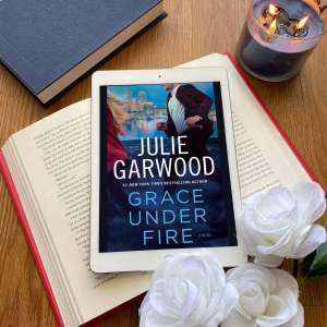 Grace Under Fire book surrounded by white roses and a blue candle