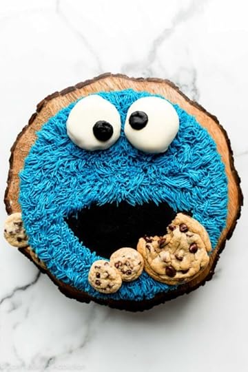 homemade decorated cookie monster cake on wooden cake stand.