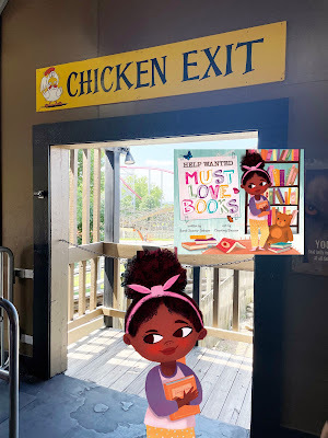 A cartoon of a dark-skinned girl with dark curly hair in a bun holds an orange book and stands in a photograph of a non-cartoon doorway with a rollercoaster in the background. Above the doorway is a sign that says