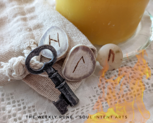Elder Futhark runes Uruz, Laguz, and Hagalaz, on a cream-colored linen cloth, with an old key