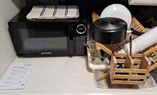 Microwave facing forward next to drying rack