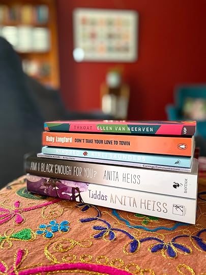 A stack of books on a table covered with a bright cloth